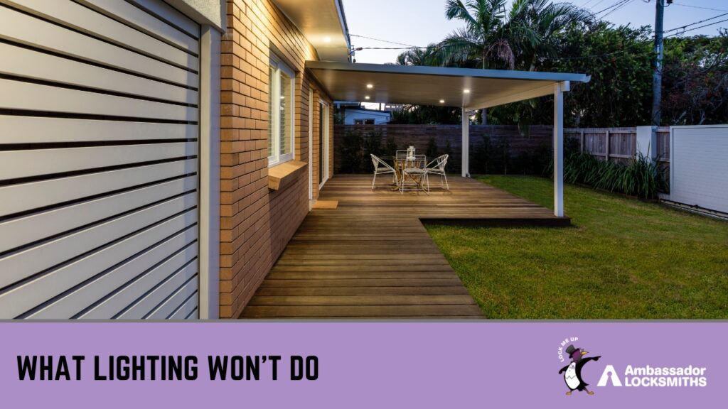 An outdoor wooden deck and patio area of a brick house at twilight, illuminated by recessed ceiling lights under a pergola.